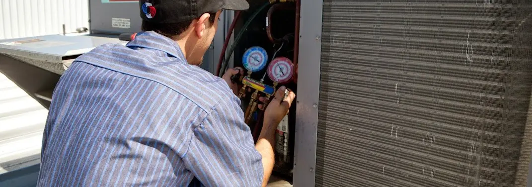 HVAC technician servicing a condenser unit in Sturgis